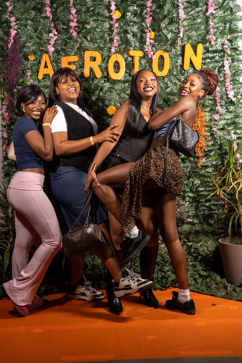 Four friends posing in front of the AFROTON wall, 27 September 2025